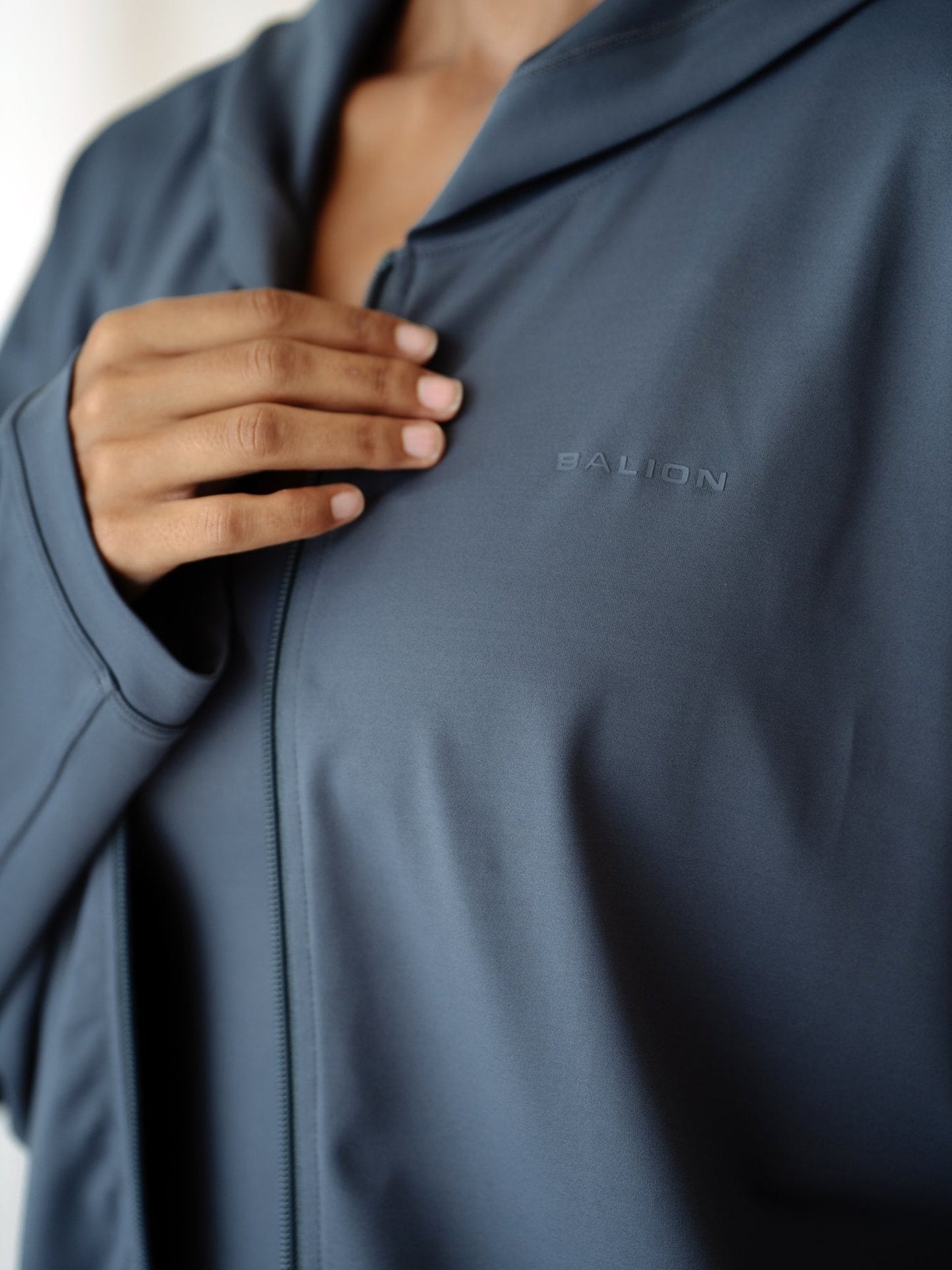 Balion Studio Flow Jacket Lunar Grey bakfra – modell i døråpning, viser hette og oversized passform