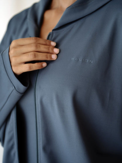 Balion Studio Flow Jacket Lunar Grey bakfra – modell i døråpning, viser hette og oversized passform